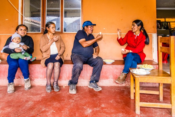 A daughter with grandchild, Nilda Olivera Lezana, Primitivo Gonzales Serrano and Georgina Conde Chura (Credit Coordinator of Caja Cusco Urubamba branch). They are eating fresh cheese and maize.